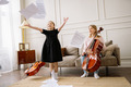 Nach dem Üben von Musikinstrumenten, schmeißt ein Kind freudig die Notenblätter in die Luft.