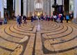 Das Foto zeigt das in den Boden eingelassene begehbare Labyrinth in der Kathedrale von Chartres mit zahlreichen Besuchern der Kirche.