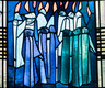 Ein Kirchenfenster in blauen Farbtönen. Es zeigt die Jünger Jesu mit Flammen über den Köpfen