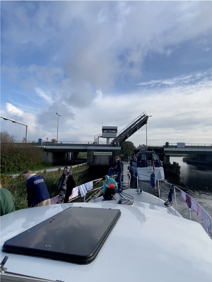 Zwei Boote direkt vor einer Autobahnbrücke, die sich grade öffnet.