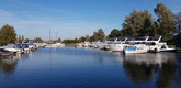 Ein weiter Blick über den Hafen von Langelille, in dem viele ähnlich aussehenden Boote liegen.