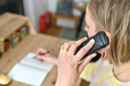 Das Foto zeigt eine Frau mit blonden Haaren an einem Schreibtisch. Sie telefoniert und ist nur leicht im Anschnitt zu sehen. Symbolbild für die Telefonseelsorge