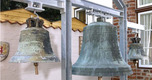 Das Bild zeigt drei historische Glocken aus dem 18. Jahrhundert im Innenhof eines Lübecker Museums