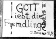 Das Foto zeigt ein Plakat von 1988 mit dem Bibelzitat "Gott liebt die Fremdlinge"